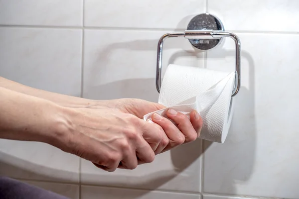 A yakın çekim ladys el kullanarak tuvalet kağıdı