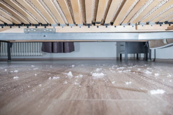 Пыль на деревянном полу под кроватью — стоковое фото