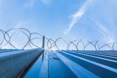 Barb tel ve mavi gökyüzü ile çit