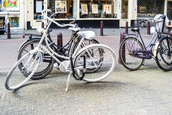 Amsterdam, Nederland - 31 April 2017: Witte fiets staande in de straten van Amsterdam — Stockfoto