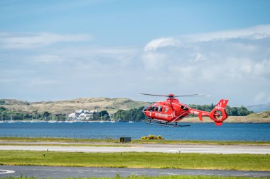 Oban Scotland - May 17 2017: Red Air ambulance starting to fly back to Ireland clipart