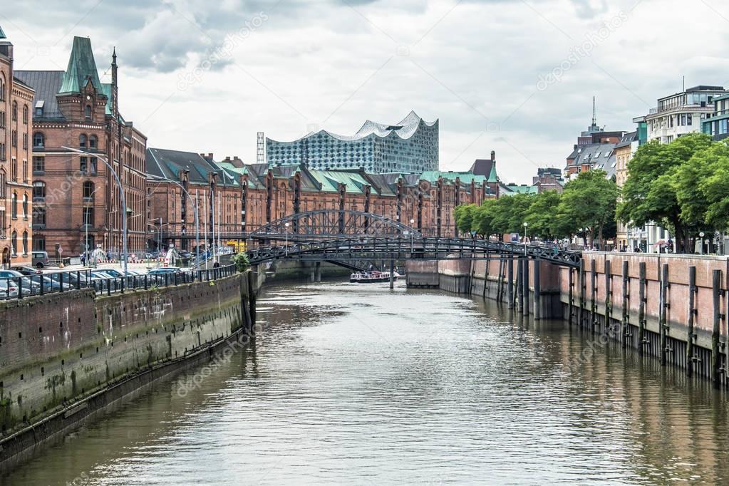 Customs channel in the old warehouse district Speicherstadt in Hamburg, Germany with Elbphilharmonie concert hall in background