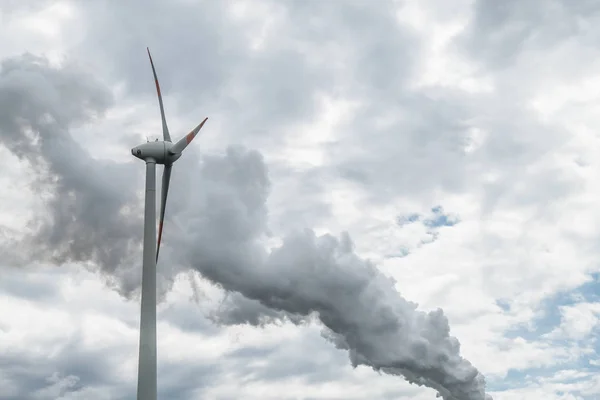 Turbina eólica situada en las nubes de contaminación de una central eléctrica — Foto de Stock