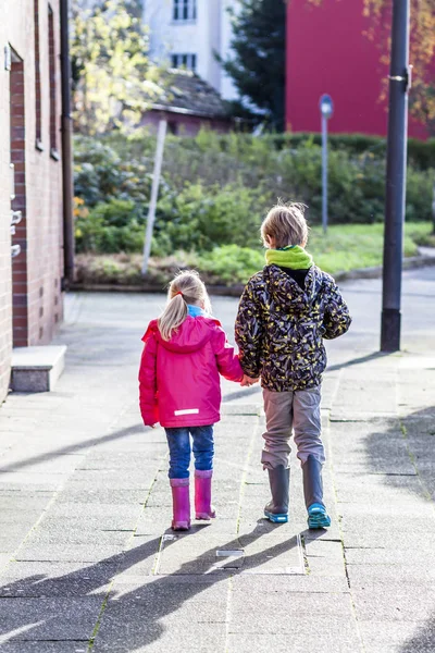 Hermano y hermana caminando de la mano en la ciudad — Foto de Stock