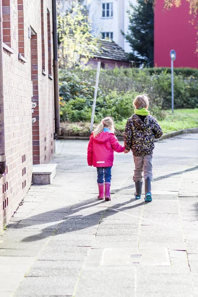 Hermano y hermana caminando de la mano en la ciudad — Foto de Stock