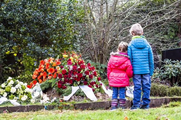 Geschwisterchen am Grab ihrer Eltern — Stockfoto