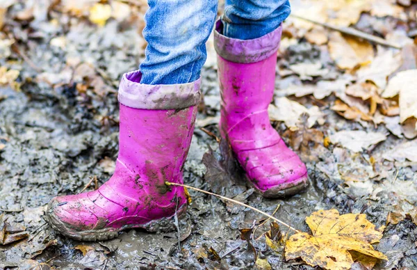 Kleines Mädchen mit rosa Wellys in der Pfütze — Stockfoto