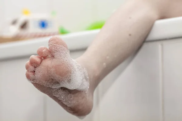 Крупный план морщинистых ног на краю ванны с пеной — стоковое фото