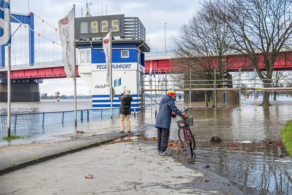 Duisburg, Tyskland - januari 08 2017: Lady förvånad av floden Rhen översvämningar strandpromenaden — Stockfoto