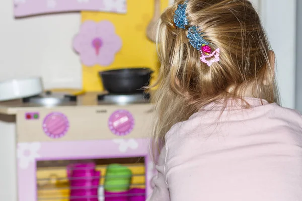 작은 소녀 요리에 그만큼 장난감 부엌 — 스톡 사진