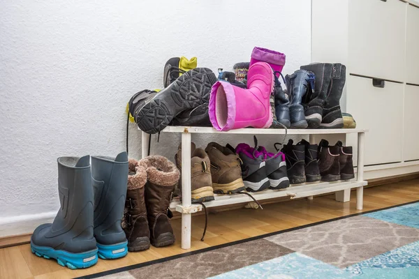 Estante con botas y zapatos sucios — Foto de Stock