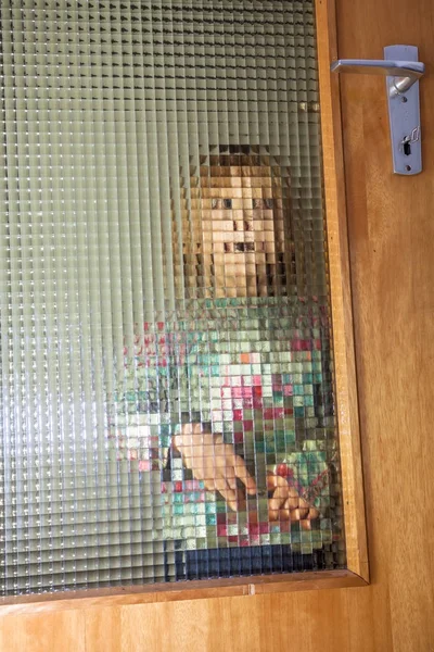 Dziewczynka za zorganizowany glas drzwi — Zdjęcie stockowe
