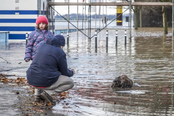 Duisburg, Tyskland - januari 08 2017: Man och dotter att observera den floden Rhen översvämningar strandpromenaden i Ruhrort — Stockfoto