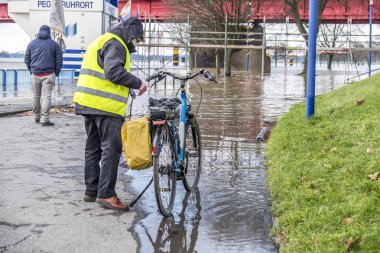 Duisburg, Almanya - 08 Ocak 2017: Ruhrort sahil alanının sel bisiklet sürücüsü sürpriz tarafından Ren Nehri
