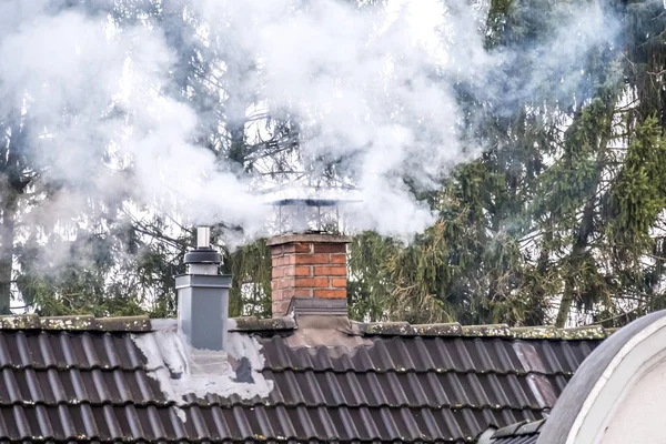 Fumar chimenea y tubería en la parte superior de una casa —  Fotos de Stock