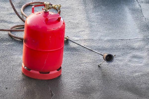 Een gasbrander van een dakdekker staande op het dak — Stockfoto