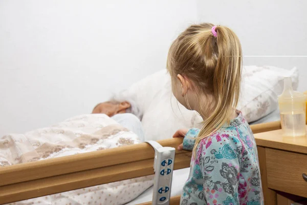 Маленькая девочка навещает свою умирающую прабабушку — стоковое фото