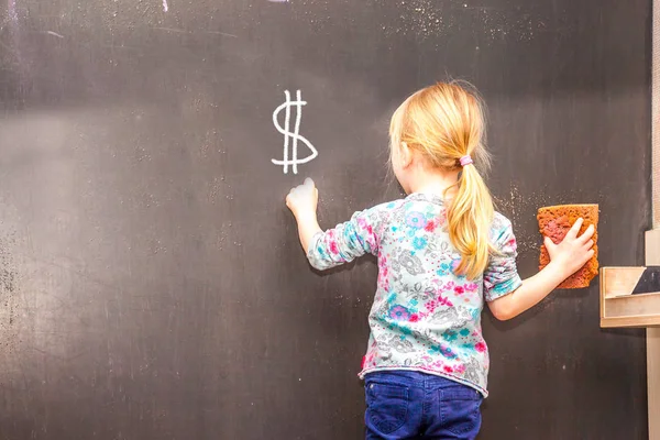 Carino bambina scrittura Dollaro segno sulla lavagna — Foto Stock