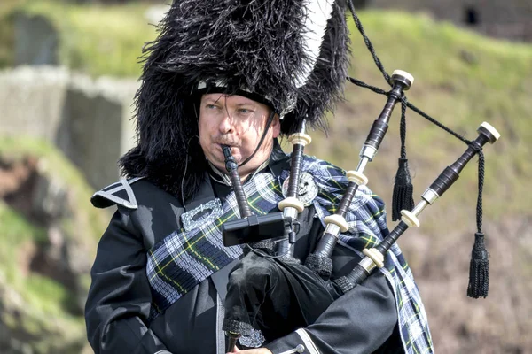 Traditioneller schottischer Dudelsackspieler in voller Kleidung auf der Burg Dunnottar in Stonehaven — Stockfoto