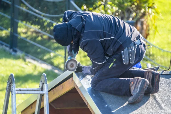 Roofer repairing the metal facing after storm — Stock Photo, Image