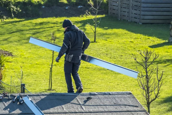 Moers, Γερμανία - 05 Φεβρουαρίου 2018: Roofer εξισορρόπησης σε στέγη με μεταλλικές στραμμένη — Φωτογραφία Αρχείου