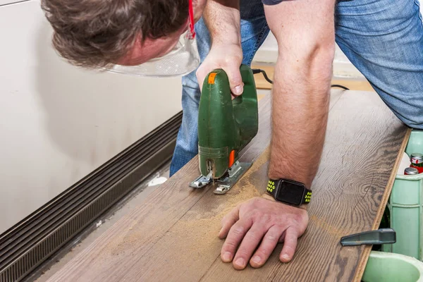 DIY werknemer snijden houten paneel met decoupeerzaag — Stockfoto