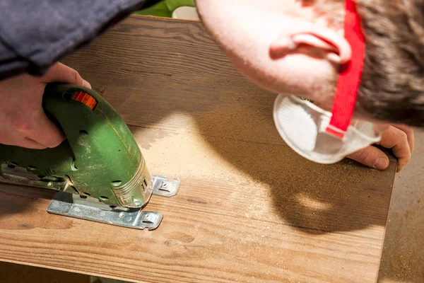 Travailleur de bricolage coupe panneau en bois avec scie sauteuse — Photo