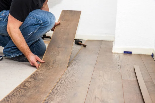 Man laying laminate in socks — Stock Photo, Image