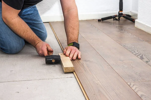 Man laying laminate in socks — Stock Photo, Image