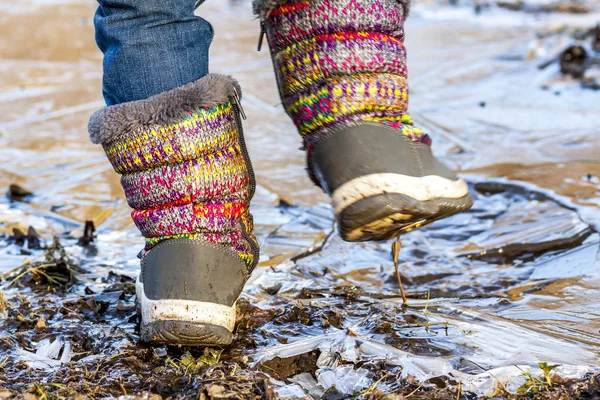 Kind steht auf eiskalter Pfütze — Stockfoto