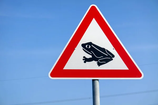 Frösche überqueren das Verkehrswarnschild — Stockfoto