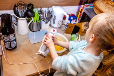 Küçük kız mutfakta bir tarifi smartphone üzerinde takip waffle pişirme