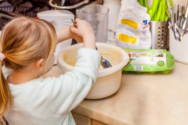 Küçük kız mutfakta bir tarifi smartphone üzerinde takip waffle pişirme