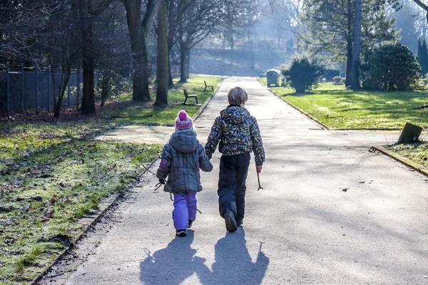 Kisfiú és a lány kezét, és séta egy hosszú egyenes úton — Stock Fotó