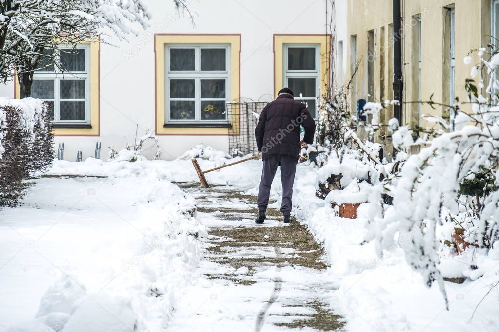 Man sweeping snow from the pavement