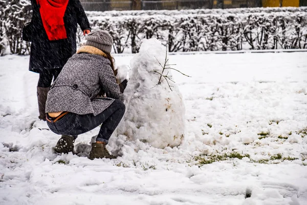 Winterkonzept der Familie baut Schneemann im Winter draußen — Stockfoto