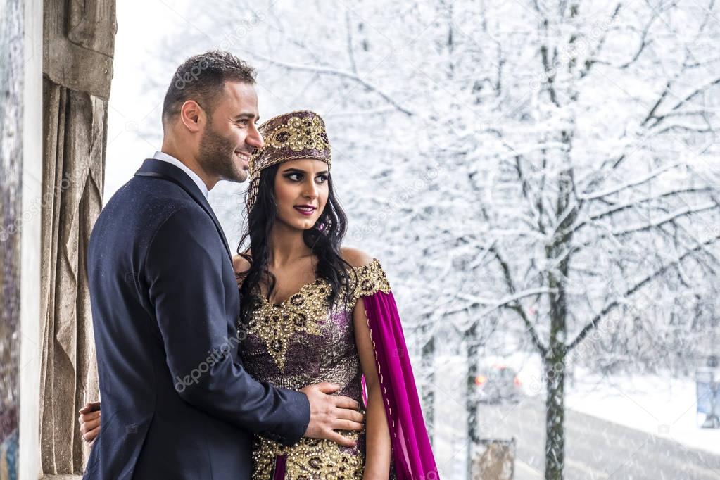 Happy couple in traditional turkish wedding dress during their wedding