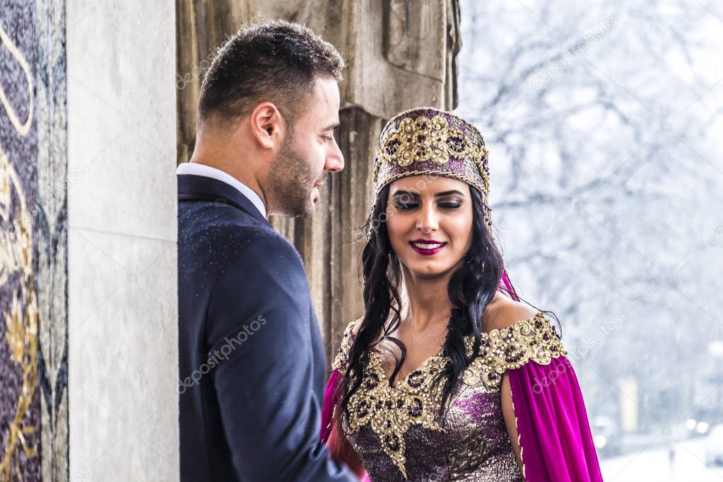 Happy couple in traditional turkish wedding dress during their wedding