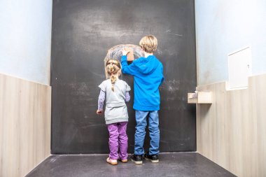 Erkek ve kız kara tahta kullanarak