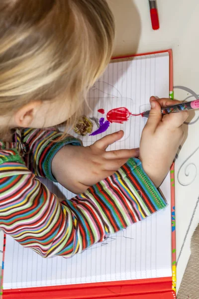 Küçük kızın bir kitapta boyama Üstten Görünüm — Stok fotoğraf