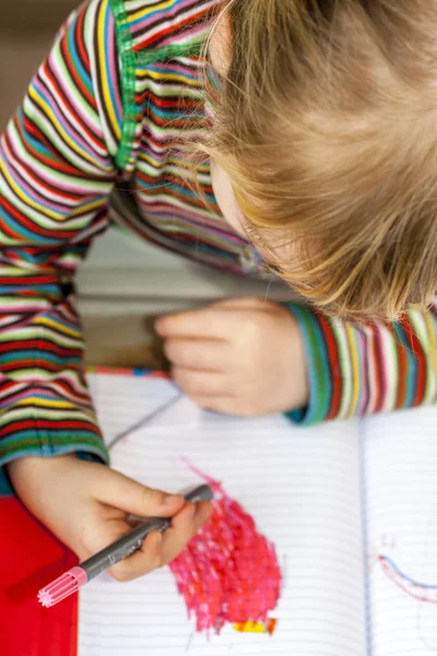 Top view of little girl painting in a book — Stock Photo, Image