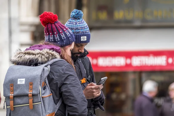 Monachium, Niemcy - 15 luty 2018: Para za pomocą smartfonu, aby ravel informacji — Zdjęcie stockowe
