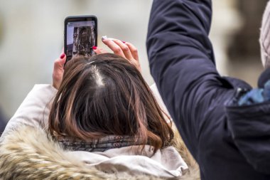 Münih, Almanya - 15 Şubat 2018: Bayan townhall smartphone ile fotoğraf çekimi