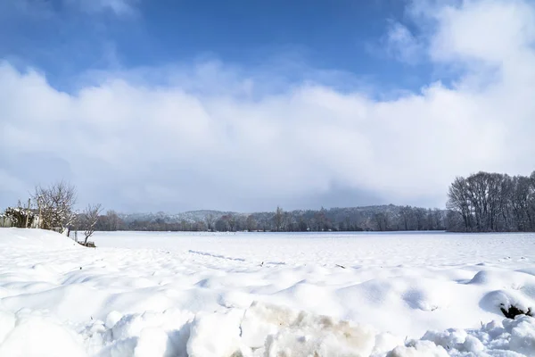 Paysage hivernal avec champ de neige à la campagne et arbres et collines à l'horizon — Photo