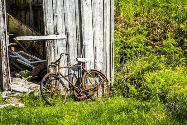 Un cobertizo abandonado en las tierras altas escocesas con una bicicleta oxidada rota afuera — Foto de Stock