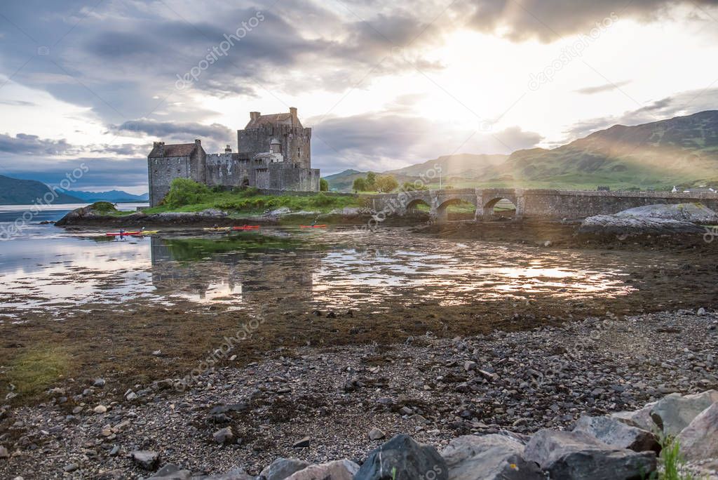 Eilean Donan Castle during sunset while canoes passing by - Dornie, Scotland