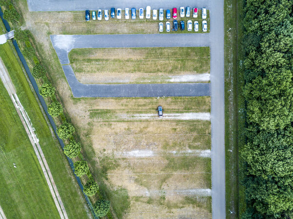 Aerial of a huge parking lot in the green.