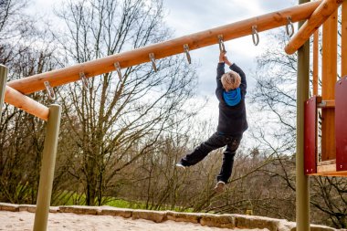 Mutlu çocuk oyun alanında merdiven üzerinde asılı