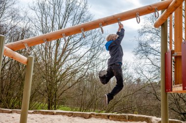 Mutlu çocuk oyun alanında merdiven üzerinde asılı