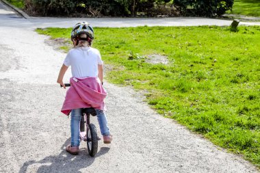 küçük kız üzerinde pembe bisiklet sürme